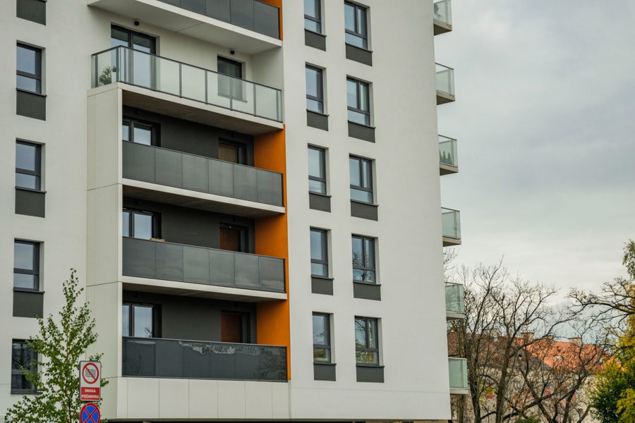Contemporary apartment building facade with balconies on a cloudy day.