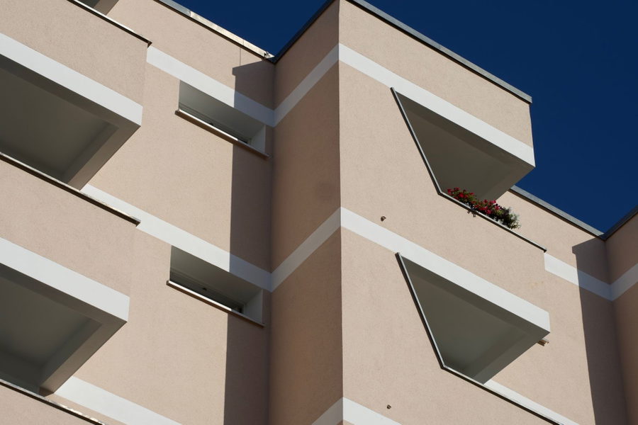 View of a modern apartment facade in Berlin, Germany with clear blue sky.