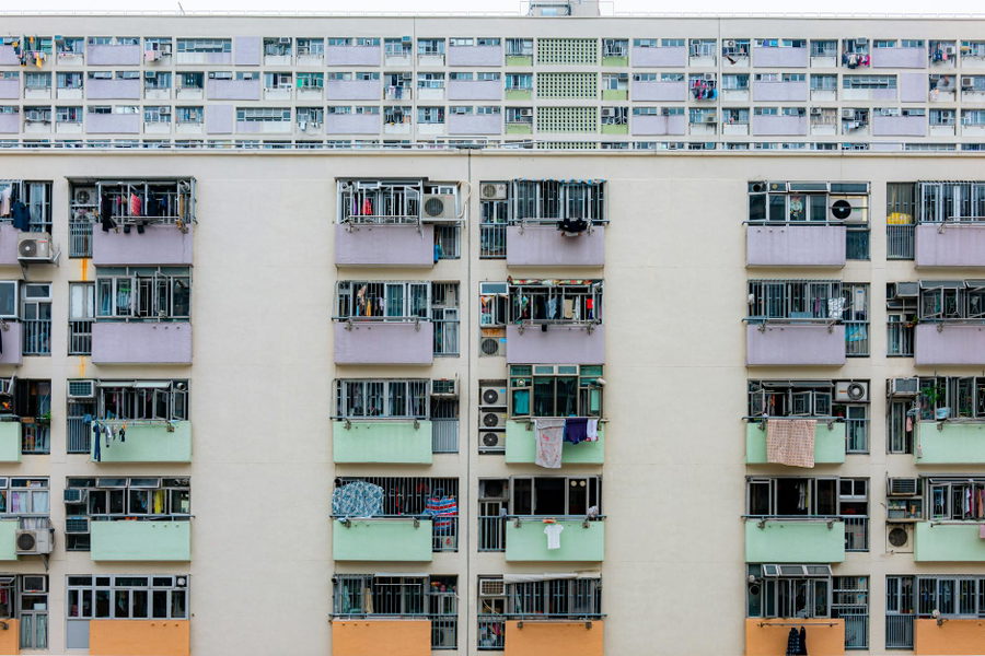 Multicolored urban apartment building with balconies and windows, showcasing city living.